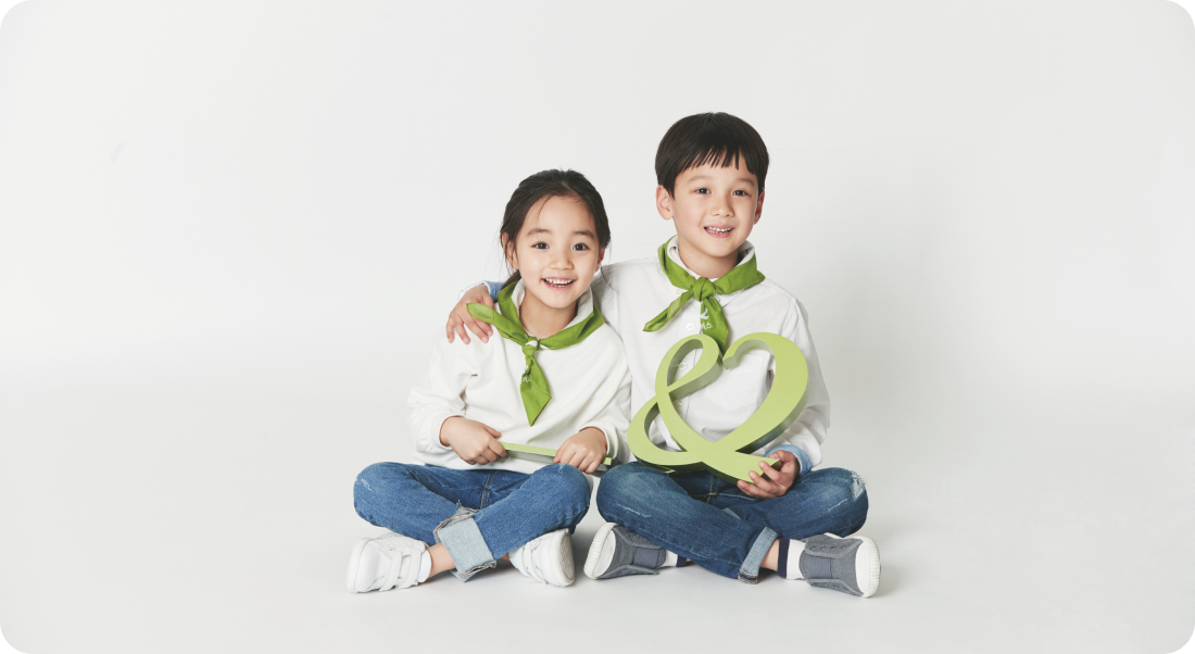 글로벌 아동권리 전문 NGO 국내 아동 후원 대표 이미지. 남자 아이와 여자 아이가 굿네이버스 CI 심볼을 들고 환하게 웃고 있는 모습