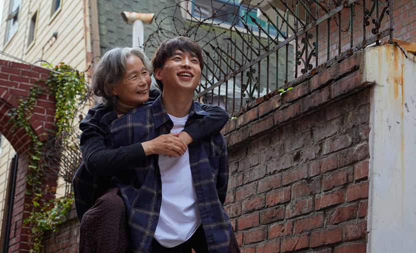 청소년이 돌봄이 필요한 가족을 업고 있는 이미지