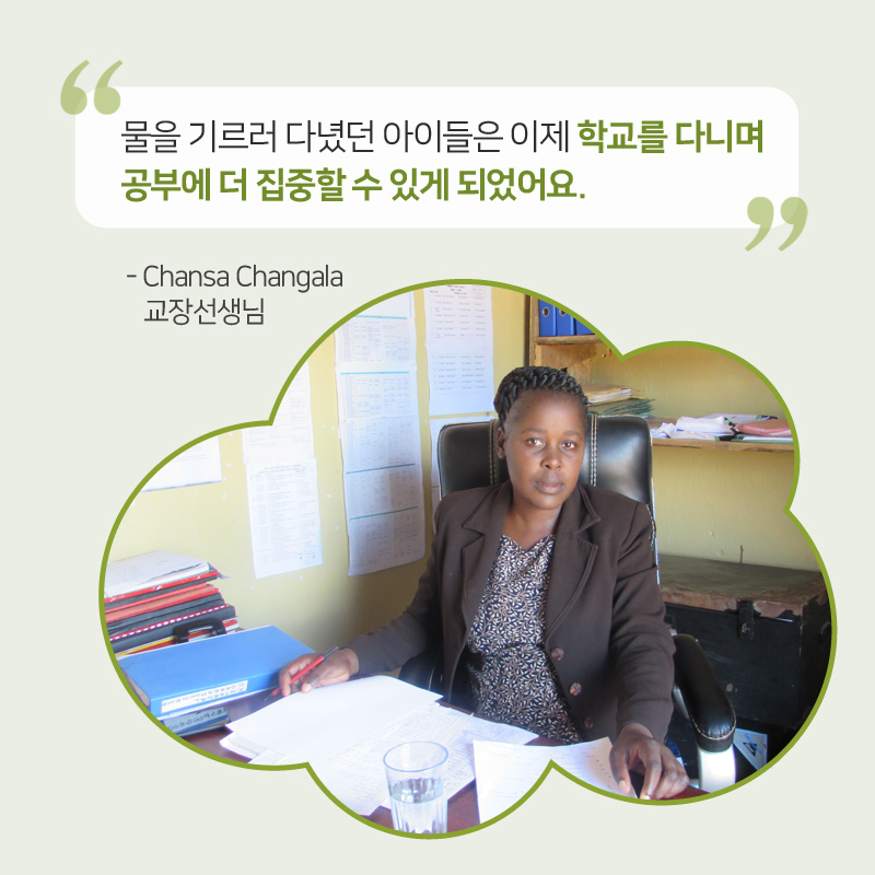 Chansa Changala 교장선생님이 책상 앞에 앉아 있는 이미지, 물을 기르러 다녔던 아이들은 이제 학교를 다니며 공부에 더 집중할 수 있게 되었어요. Chansa Changala 교장선생님