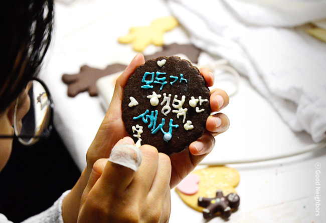 굿멤버스데이에서 쿠키 위에 모두가 행복한 세상이라고 쓰고 있는 회원님 이미지