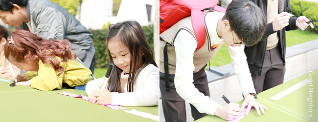 굿네이버스 세계빈곤퇴치의날 캠페인에 참여하여 희망리본에 빈곤퇴치에 대한 바램을 적고 있는 시민들 이미지