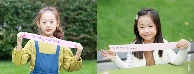 자신들이 적은 희망리본을 들고 있는 아이들 이미지