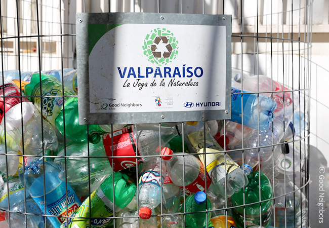 발파라이소라는 팻말이 붙어 있는 통안에 재활용 쓰레기가 모여 있는 이미지