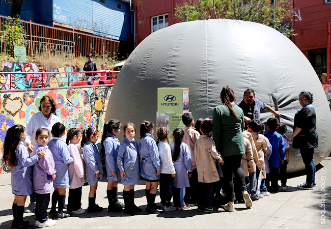 교사들과 아동들이 이동식 돔교육장 앞에 줄을 서고 있는 이미지