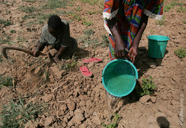 물이 부족해서 땅이 척박하게 메말라 있어 그 땅에 물을 붓고 있고 옆에서 아이가 농사를 짓기 위해 곡괭이로 땅을 파고 있는 이미지