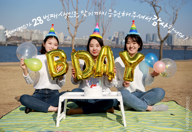 굿네이버스가 28번째 생일을 맞기까지 응원해주셔서 감사합니다!, 왼쪽부터 보호미, 나누미, 기쁘미가 풍선을 들고 축하하는 모습