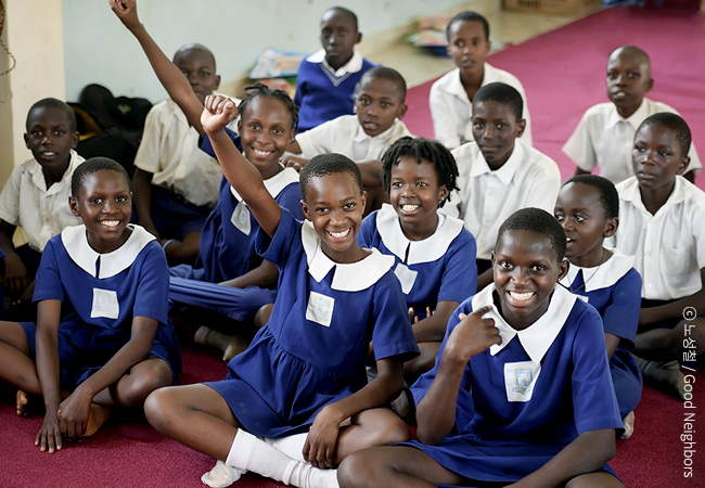 교실에 모여 앉아 손을 들고 환하게 웃으며 한 명 씩 자신의 꿈에 대해 발표하고 있는 아이들의 모습