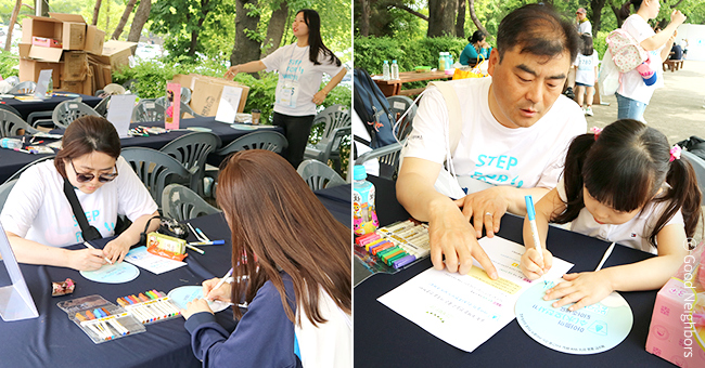 굿멤버스데이에 참여한 회원들이 지구촌 아동들의 현실을 알리기 위한 문구를 부채에 적어 옹호 부채를 만들고 있는 이미지