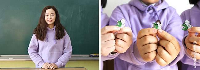 마산여자중학교 맹나경 선생님의 모습과 학생들이 배지를 들고 있는 모습