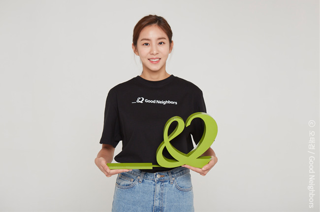 배우 유이가 굿네이버스 CI를 들고 웃고있는 모습