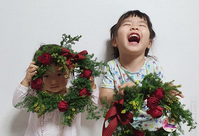 굿멤버스데이 직접 만든 리스를 들고 웃고있는 두 아이의 모습