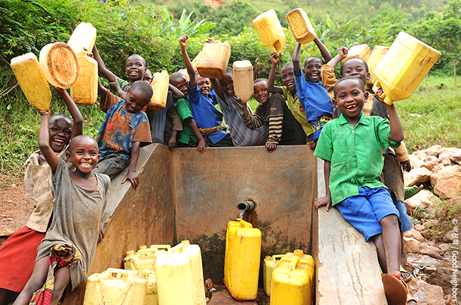 식수시설 앞에서 물통을 들고 환하게 웃고 있는 아이들의 모습
