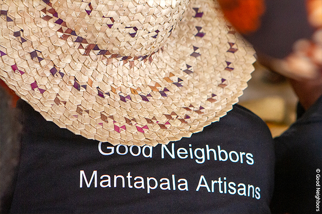 잠비아 난민캠프에서 만들어진 모자를 쓰고 있는 굿네이버스 직원