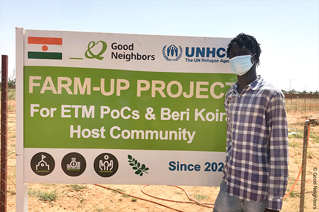 데르가 농업훈련프로그램 간판 앞에 서 있는 모습