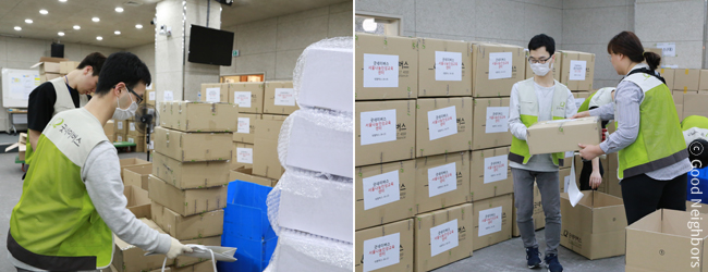 산더미처럼 쌓여 있는 반짝반짝 선물상자를 전국 굿네이버스 지부로 배송될 박스 안에 옮기고 있는 자원봉사자들의 모습