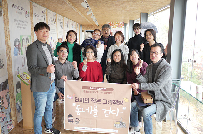 초록색 츄리닝을 입고 하얀색 머리띠를 두른 성인 남성이 머리를 만지며 고민하는 이미지