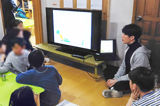 왼쪽은 윤재영님이 지역아동센터 아이들 앞에서 수업하고 있는 모습, 오른쪽은 수업에서 상을 받은 아이들과 윤재영님이 함께 상품을 들고 있는 모습