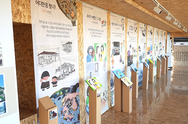 초록색 츄리닝을 입고 하얀색 머리띠를 두른 성인 남성이 머리를 만지며 고민하는 이미지